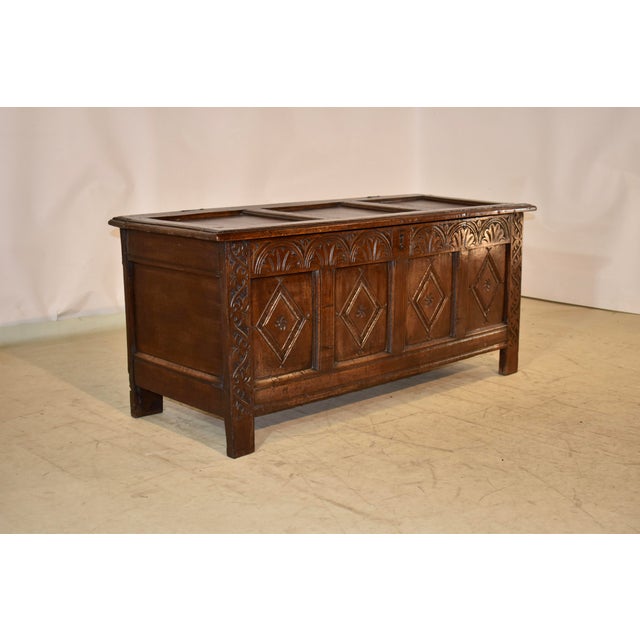 Early 18th century oak blanket chest from England. the top has three panels, surrounded by a frame with a beveled edge....