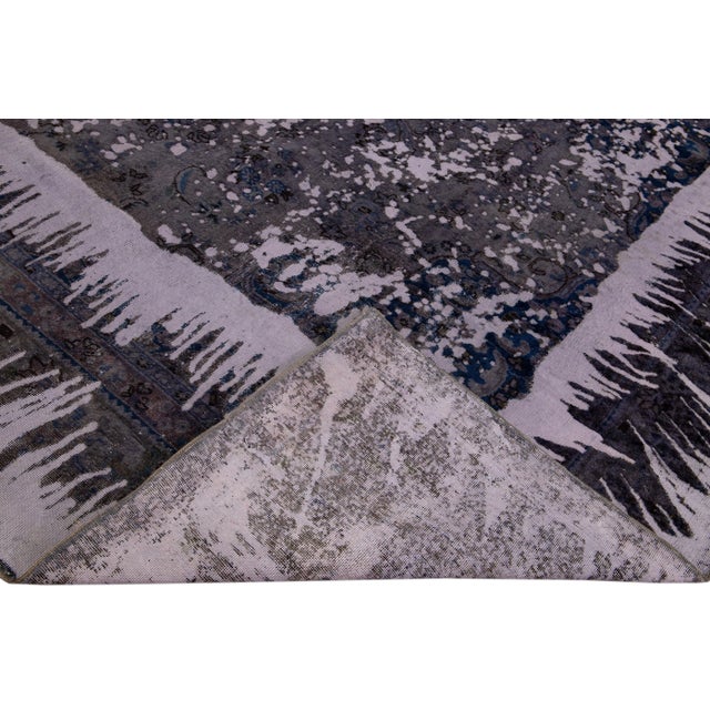 Beautiful hand-knotted vintage Persian wool rug with a gray field. This distressed rug has blue accents featuring a...