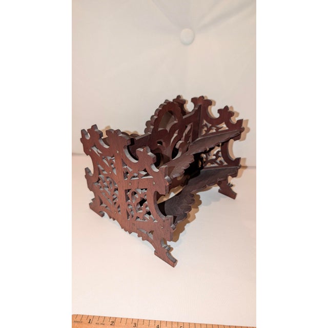 Walnut stereo view holder with four shelves. Ends and center contain intricate fretwork cutouts. One shelf has missing...