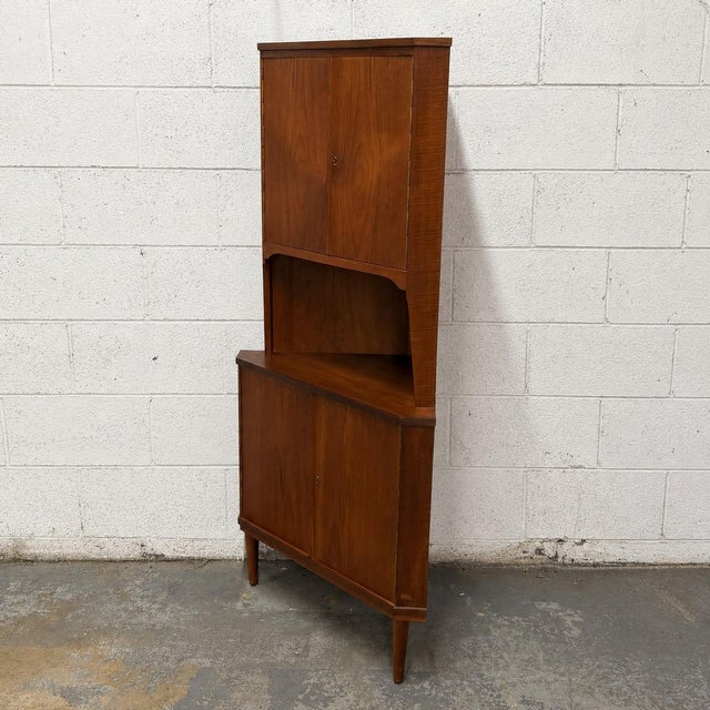 A vintage Danish teak corner cabinet from the 1960s with a tall, narrow form designed to make good use of a room’s corner....