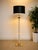 A striking vintage floor lamp combining clear Lucite, warm brass-tone accents, and a built-in square side table for a...