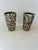 Set of two shot glasses with a silver overlay. The overlay has etched leaves and a woven design.