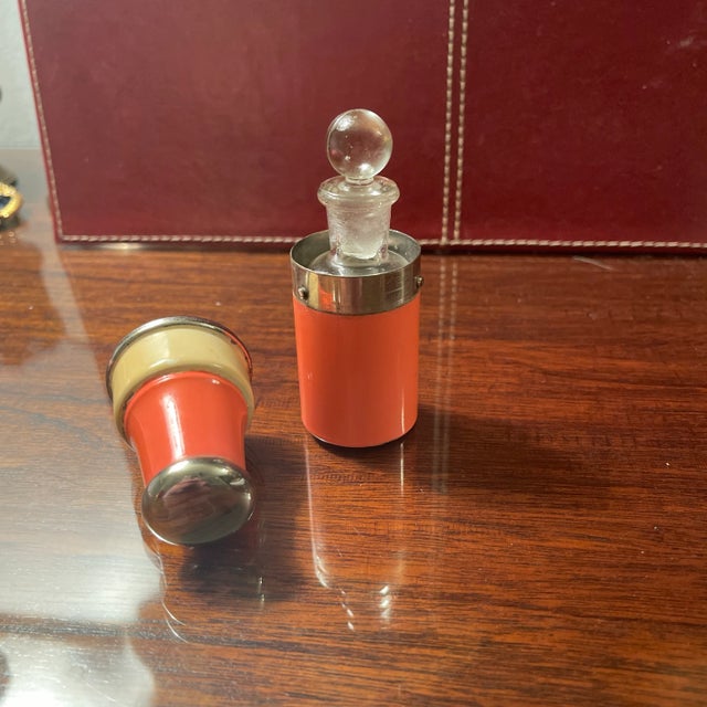 Antique French travel perfume or cologne bottle. The painted metal case has a spring loaded lid with a cork that keeps the...