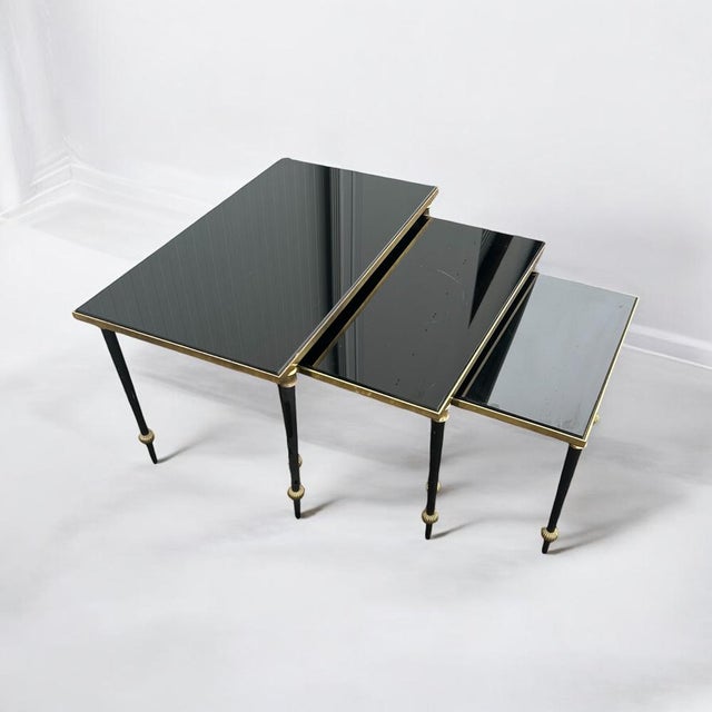 Set of three neo-classical nesting tables in brass and black opaline glass, originally from the 1950s. Small: 43/37 cm,...