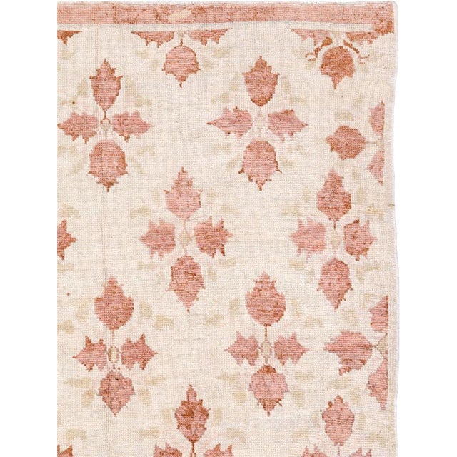 This Mid-20th Century Turkish Anatolian rug presents a delicate allover floral composition arranged across a warm ivory...
