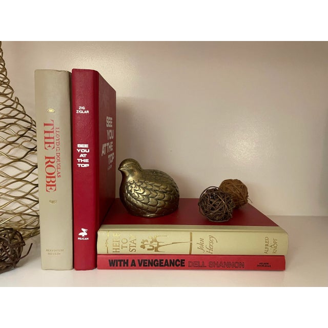 Add color and interest to your shelf or coffee table with this intriguing collection of vintage books in Red and Beige....