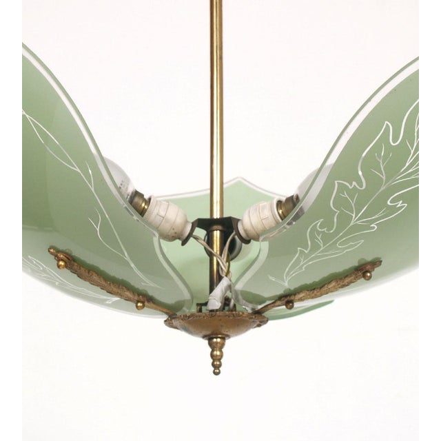 1920s Refined three-light Art Deco chandelier, with three leaves in green colored Murano glass The good and correct...