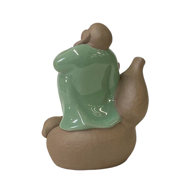 This is a Chinese decorative ceramic pottery figure of a fat Happy Buddha on a gourd. It can be an incense holder....