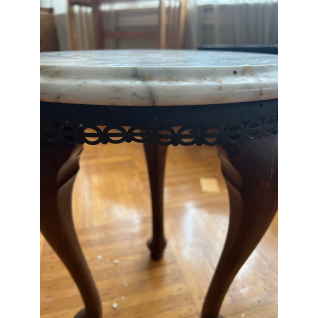 Likely late 19th-century Victorian marble-top side table featuring a round white marble top, a reticulated brass apron,...
