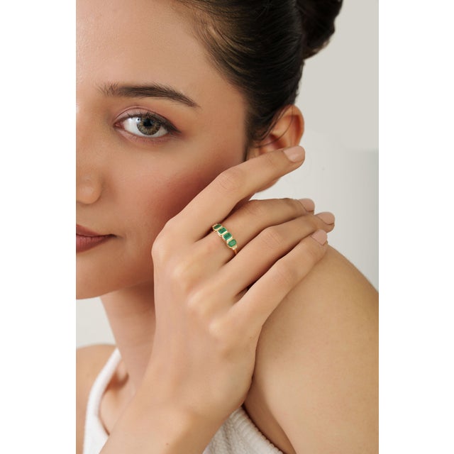 This band ring features a 1-carat octagon emerald set in 14K yellow gold. The emerald measures approximately 4.72 x 3.84...