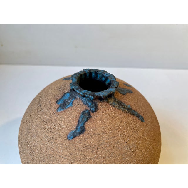 Interesting ball or onion shaped vase in un-glazed ceramic. It features intended spiky imperfections to its neck that are...