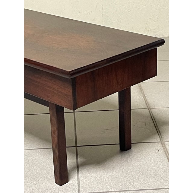 A low coffee table with built-in drawers or a small entryway chest from the 1960s, featuring a minimalist design typical...