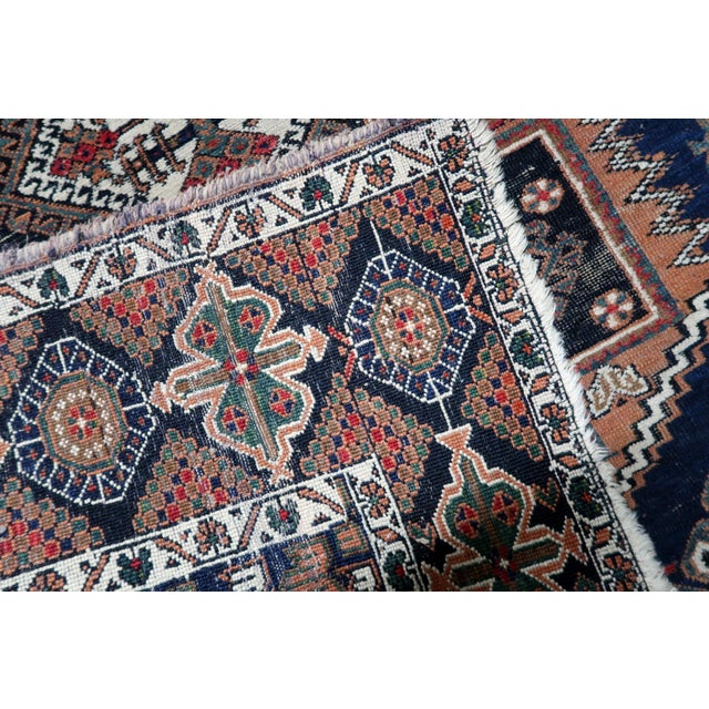 A handmade antique Persian Afshar rug from the 1920s, woven in wool and showcasing the expressive tribal artistry of the...