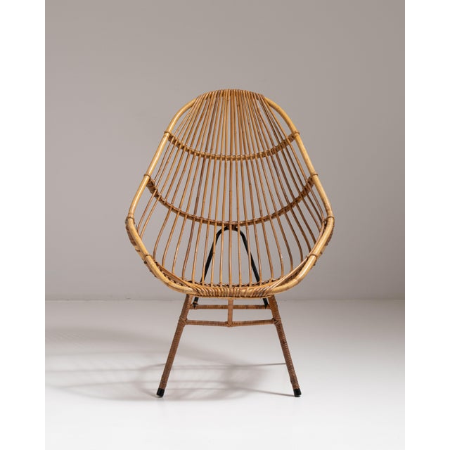 This 1960s bamboo upholstered bowl chair from France is woven in bamboo and rattan as an egg-shaped bowl chair with a...