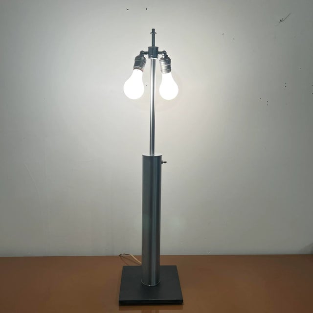 Walter Von Nessen brushed steel table top lamp with black base. Lamp is in good working condition. Shade is not included....