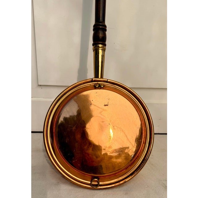 This antique copper and brass bed warmer dates to the late 19th to early 20th century, approximately 1880–1920....