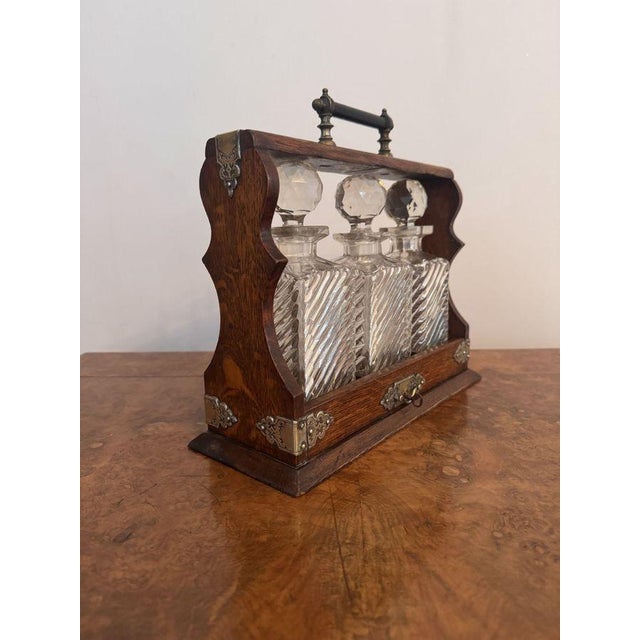 Fantastic quality antique Victorian tantalus, having a quality antique Victorian oak tantalus containing three quality...