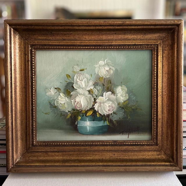 Vintage signed floral still life featuring white roses arranged in a turquoise vessel against a soft green-blue...