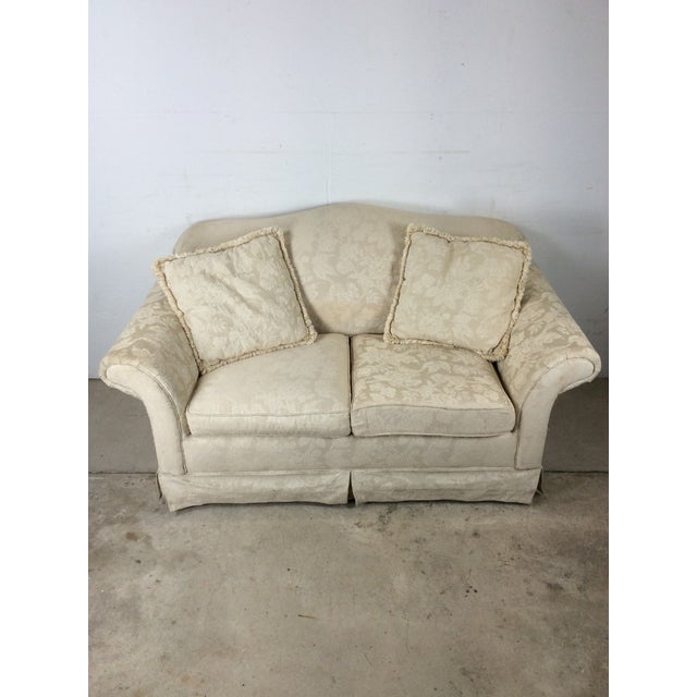 This vintage loveseat sofa features two seater design, original white fabric upholstery with floral pattern, and removable...