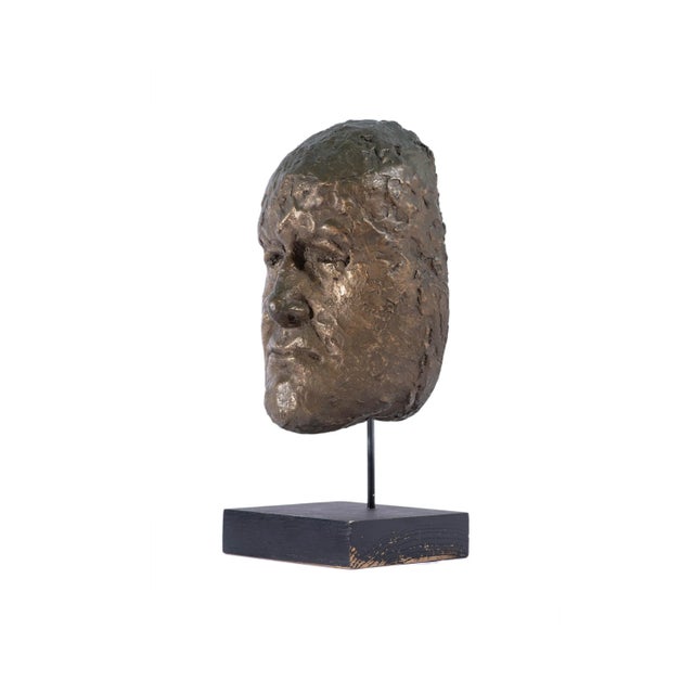 A mid-century abstract sculpture of a face. Composed of bronze, the Brutalist style sculpture forms a mask-like shape with...