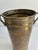 Vintage solid brass Hosley vase with a raised grapevine motif, rolled rim, and curved side handles. The warm, varied...