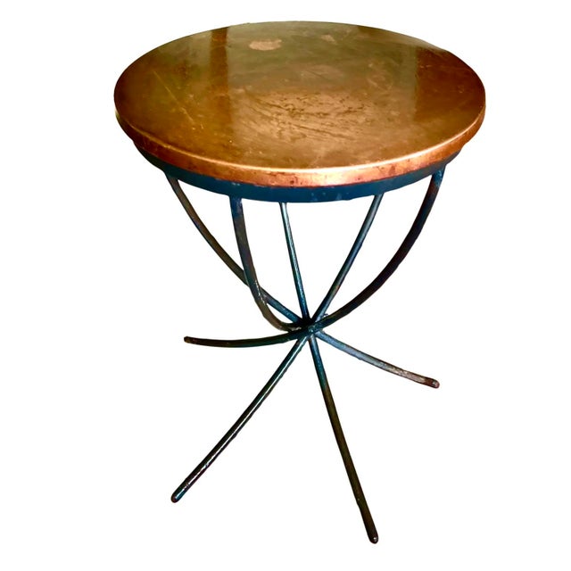 Transitional copper top side table with naturally patinated finish. Suspended on curved wrought iron legs. Circa 2010s.
