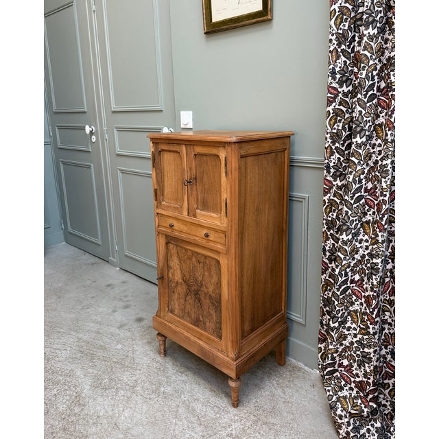 This small, tall antique walnut sideboard is distinguished by its narrow profile and decorative front. Likely dating from...