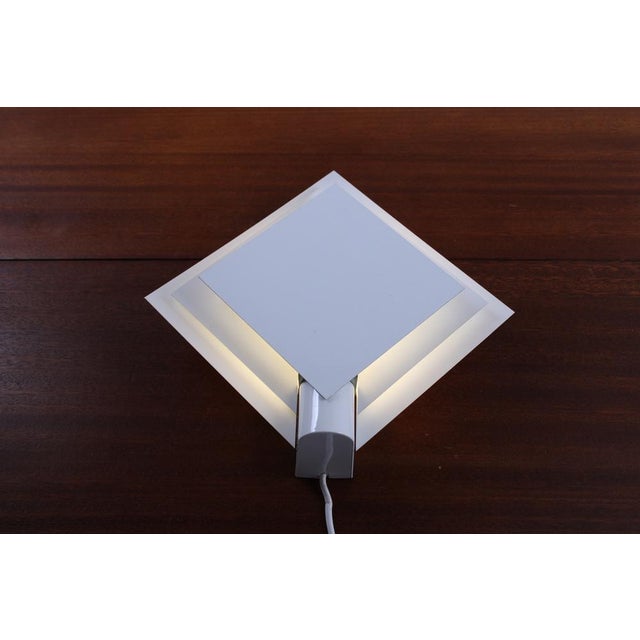 Small metal wall lamp in characteristic 1980s style. The lamellae allowing light to shine through in an atmospheric way....