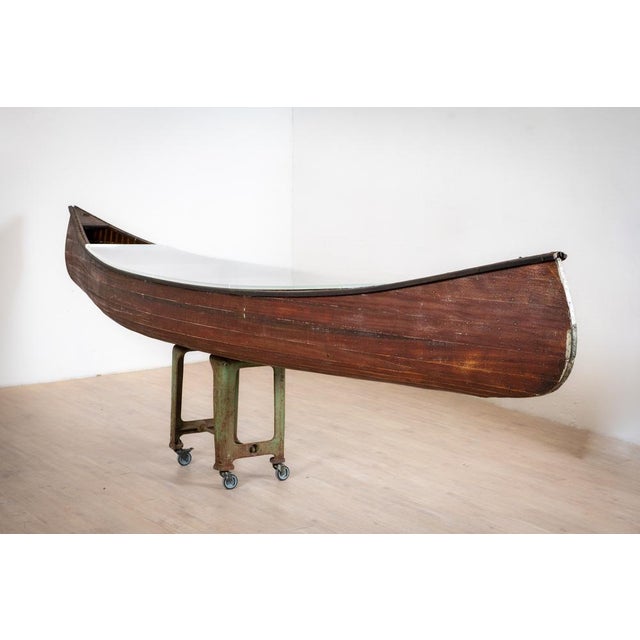 On the basis of an industrial workshop base in cast iron, mounted on a roulette, firmly rests a Canadian canoe,...