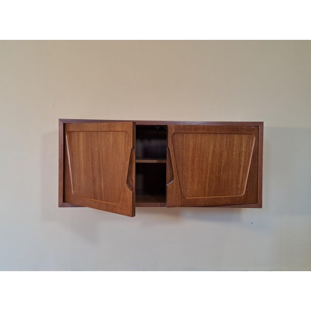 Rival Wall-Mounted Teak Storage Unit, 1960s, in Very Good conditions. Designed 1960 to 1969 This piece has an attribution...