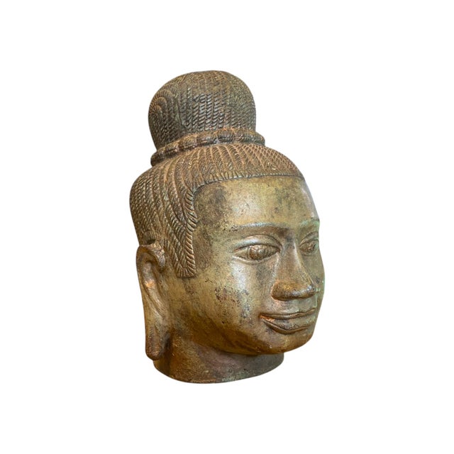 Antique-style bronze Buddha head sculpture inspired by the Khmer Baphuon period (11th century Cambodia), characterized by...