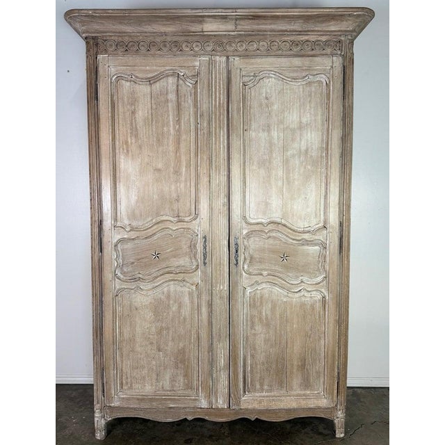 A beautifully timeworn French Provincial armoire, crafted in solid oak and retaining a richly aged, cerused surface that...