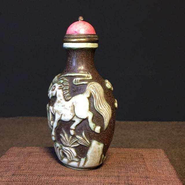 This is a charming vintage Chinese snuff bottle, crafted from Liuli (traditional Chinese glass). The bottle features a...
