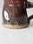 This vintage handmade pottery mug features a slightly barrel-shaped form and a rich, variegated glaze in deep browns and...