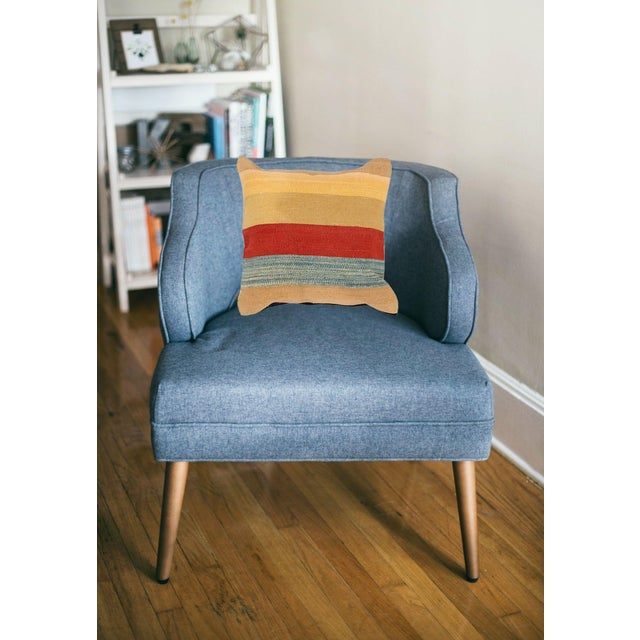 A one-of-a-kind handwoven wool kilim pillow featuring a beige ground with bold red, teal, and yellow stripes. Fully...