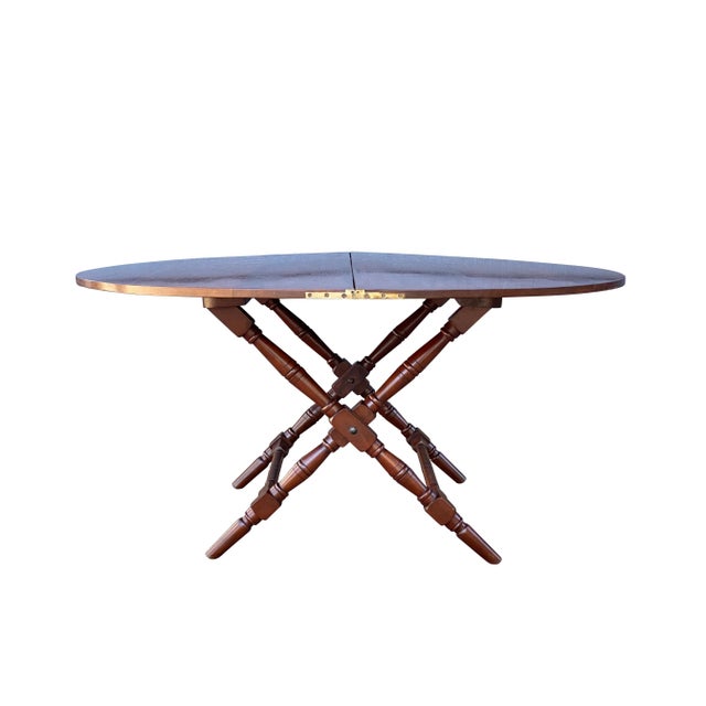 Circular when open and folds with brass hinges and fittings and stays closed with a latch. Simple turned legs with stretcher.