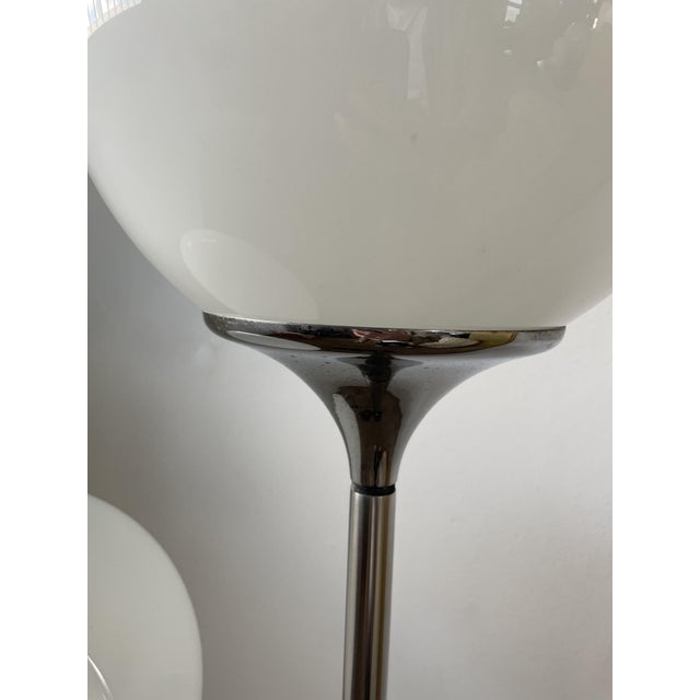 Pair of Lamperti lamps with original opaline glass resting on a ceramic base, steel stem with interlocking cast iron base...