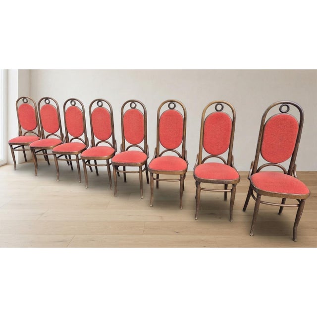 A set of vintage bentwood dining chairs by Thonet, dating from the 1970s. The chairs feature tall rounded backrests with...