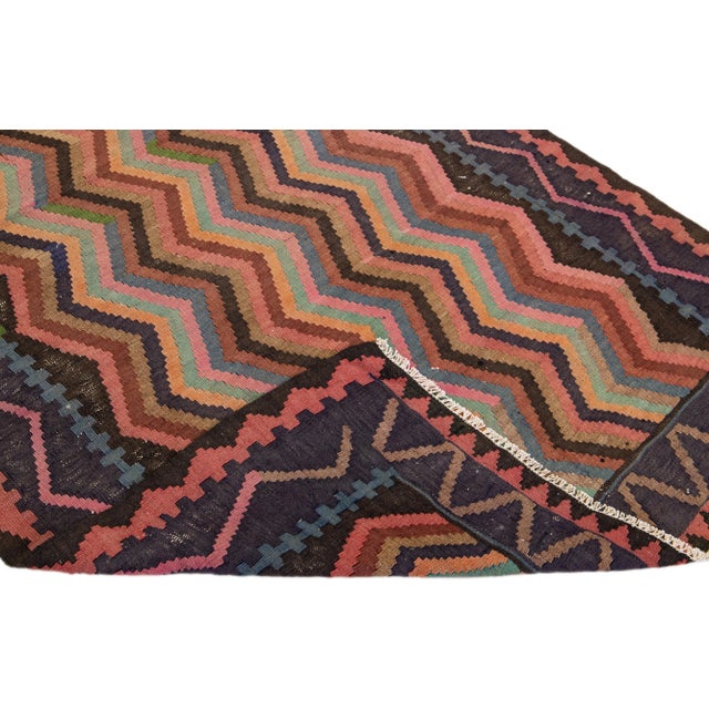 Beautiful vintage Turkish Kilim hand-knotted wool rug with a pink field. This piece has a blue frame and multicolor...