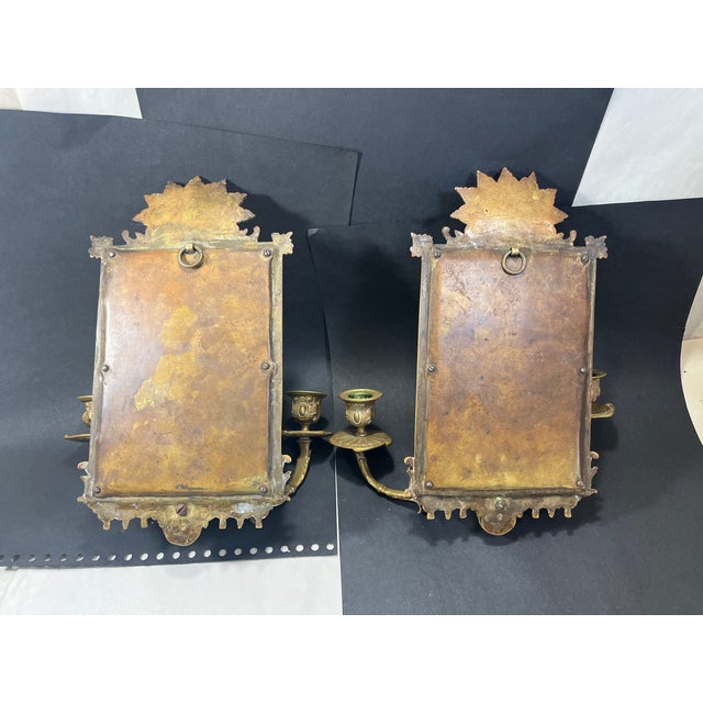 Exceptional pair of gilt bronze sconces, each having a pair of candle holders, with lion head accents on bottom and fan...