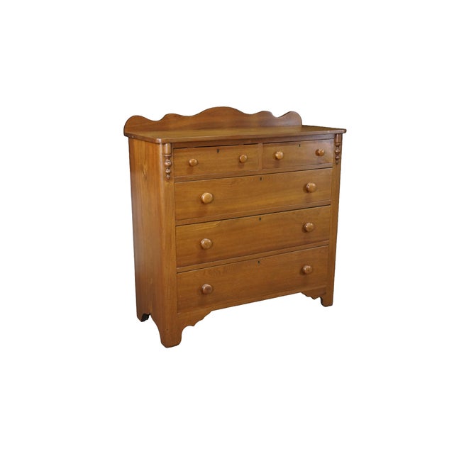 19th-century Victorian chest of drawers, constructed from solid walnut wood, showcasing a warm, honey-toned finish that...