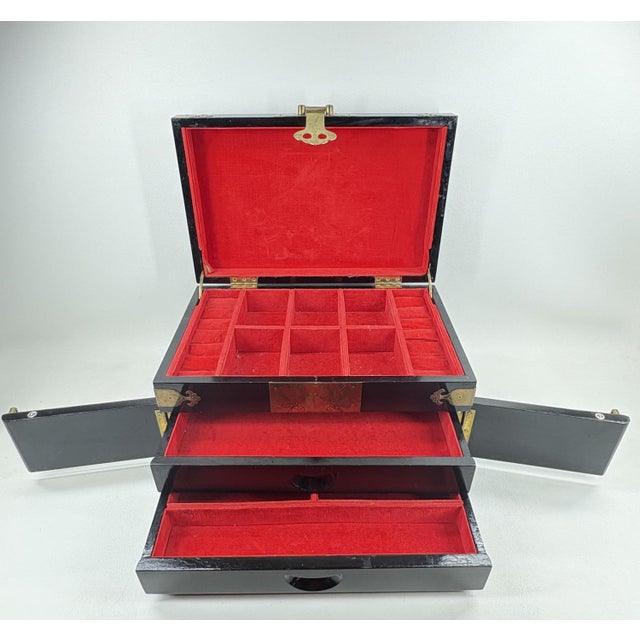 Large Vintage Chinese Black Lacquer Jewelry Box with Ornate Brass "Fu" Detail This striking vintage jewelry chest features...