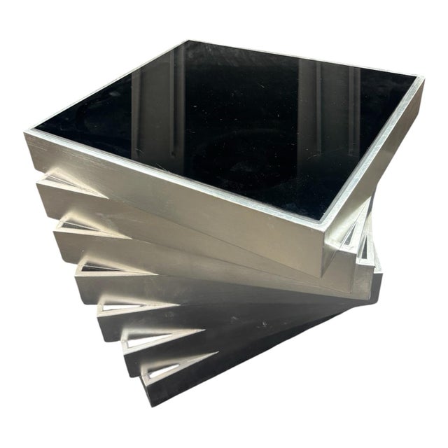 This product is a pair of mid-century modern silver leaf and black glass stair side tables. The tables are made of wood...