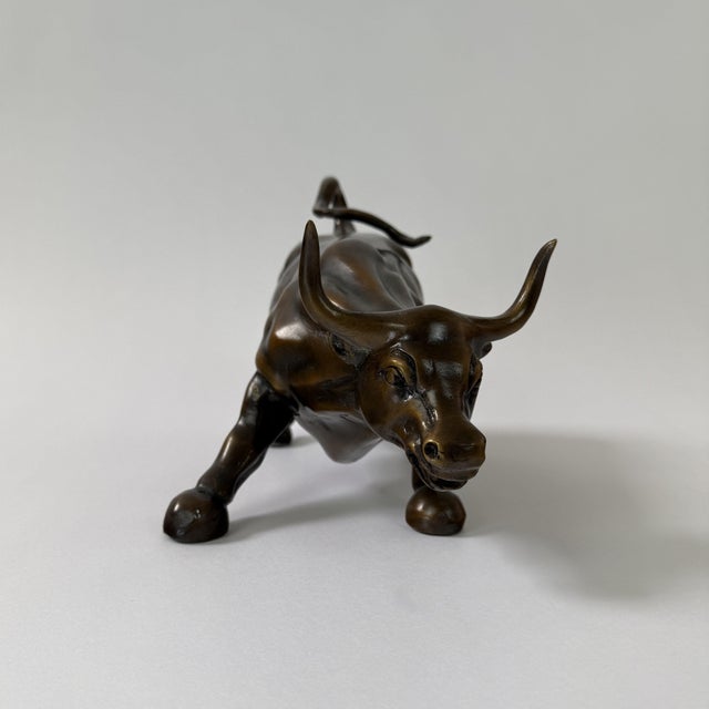 A bronze sculpture of a charging bull, inspired by the iconic “Wall Street Bull” and symbolizing strength, momentum, and...