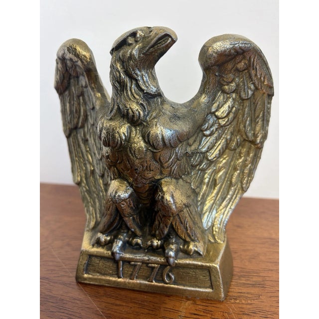 Vintage brass-tone bald eagle bookend featuring spread wings and a “1776” base. Classic American patriotic/Federal-style...