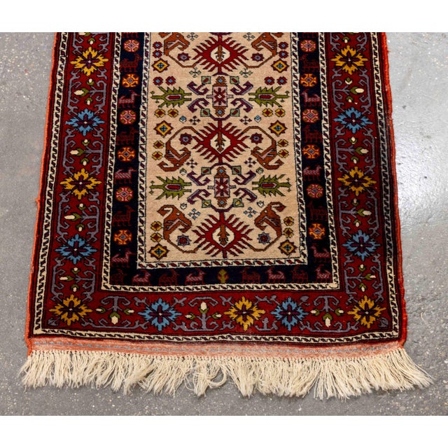 Persian Kazak Wool Runner, with animal and floral design on red ground. 11' 6" x 2' 8" W. Provenance: From a Central Park...