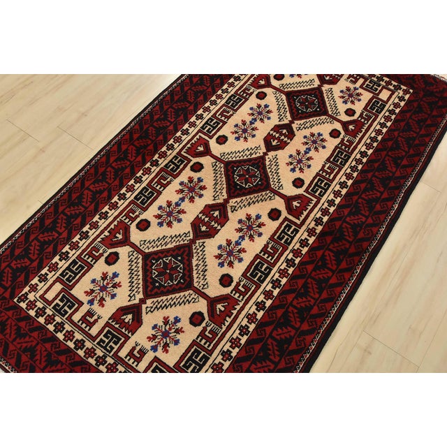 An authentic vintage tribal Baloch rug hand-knotted with fine wool and natural dyes. This nomadic rug features geometric...