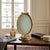 Antique French tabletop vanity frame in a Neoclassical style, constructed in gilt brass or bronze with an oval cross-...
