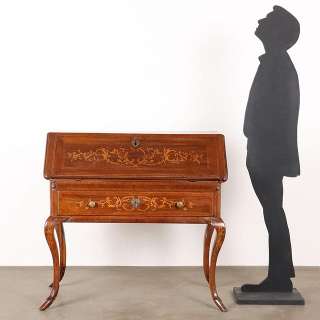 Piedmontese folding desk in walnut with floral inlays and volutes in maple and olive wood frames. Internal cabinet...