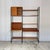 A two-bay ladderax shelving system by staples: three black metal ladders, two cabinets and six shelves. Everything hangs...